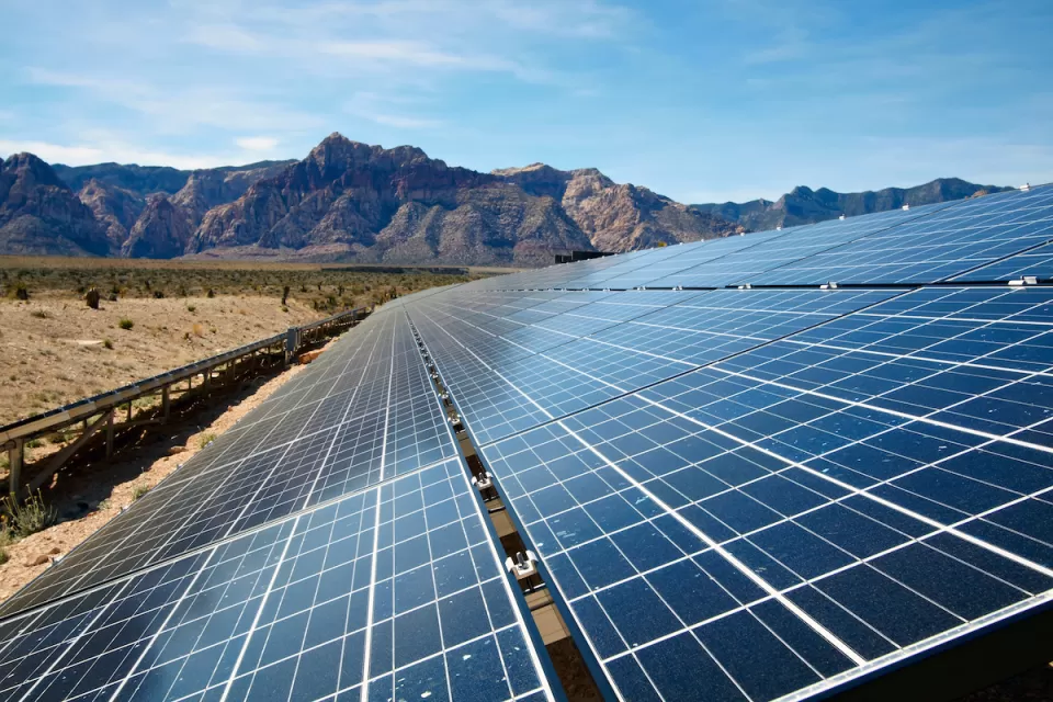 Solar panel array with Mojave Desert mountains in background.